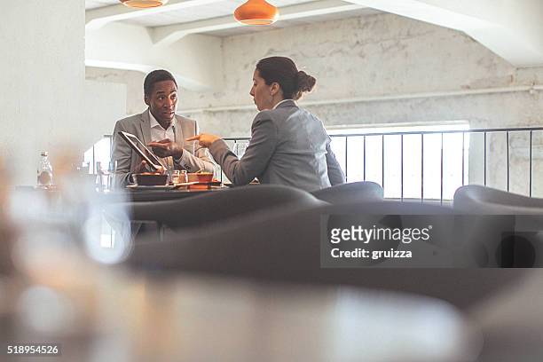 young businesswoman and man having a business conversation at restaurant - face to face interview stock pictures, royalty-free photos & images