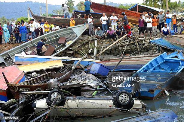 This photo taken 26 December 2004 shows fishing boats and a car among the debris along the coast of Langkawi island, northwest Malaysia, after a...