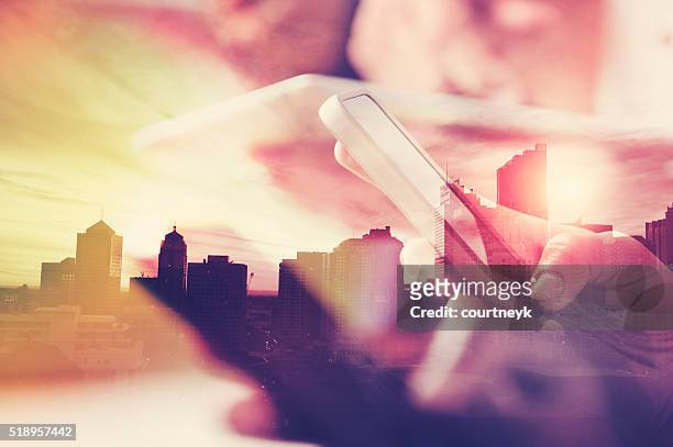 mobile phone in hand with city skyline. - worldwide businessman stockfoto's en -beelden