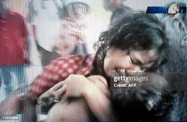 This television grab taken 27 December 2004 shows a woman grieving as she holds the body of her dead child in Aceh as a massive 9.0 magnitude...