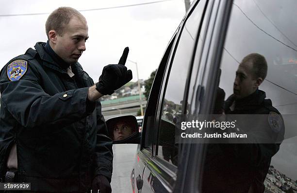 California Highway Patrol officer Mike Robinson gives a sobriety test to a man in car at a sobriety checkpoint December 26, 2004 in San Francisco,...