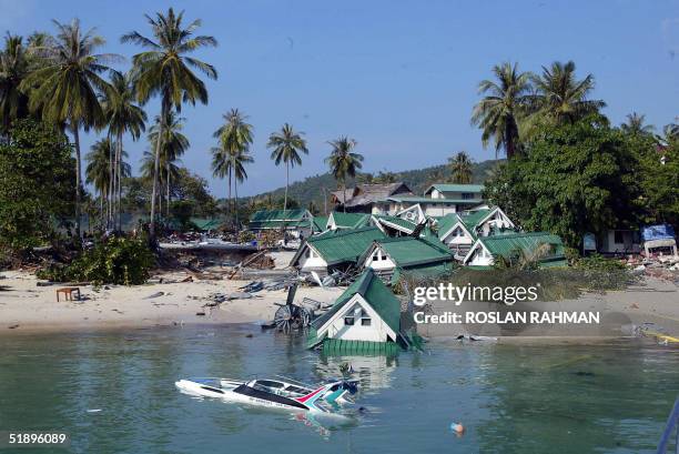 Boat and one of the gift shops building submerge on the beach of Phi Phi island in southern Thailand's holiday resort which was destroyed by a tidal...