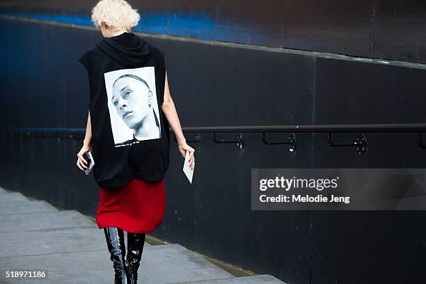 Ola Karput wears a black David Sims x Raf Simons “Isolated Heroes” sleeveless hoodie with a black and white David Sims photo on the back, Lemaire,...