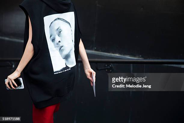 Ola Karput wears a black David Sims x Raf Simons “Isolated Heroes” sleeveless hoodie with a black and white David Sims photo on the back during...