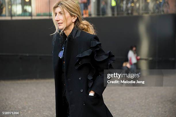 Sarah Rutson of Net-A-Porter wears a Junya Watanabe black trench coat with ruffle sleeve details during London Fashion Week Autumn/Winter 2016/17 at...