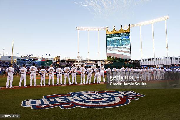The Kansas City Royals and the New York Mets line the field during the National Anthem ahead of their opening day game at Kauffman Stadium on April...