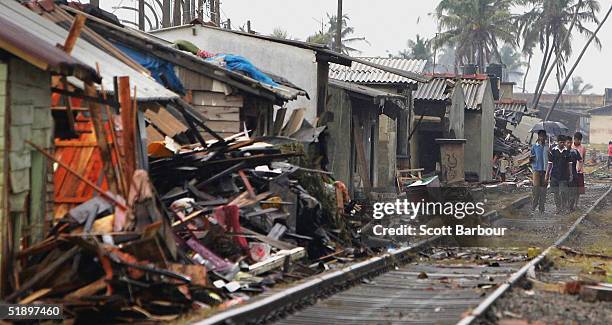 People survey the damage after a massive tsunami swept across coastal Sri Lanka, December 28, 2004 on the coast of the Wadduwa district near Colombo,...
