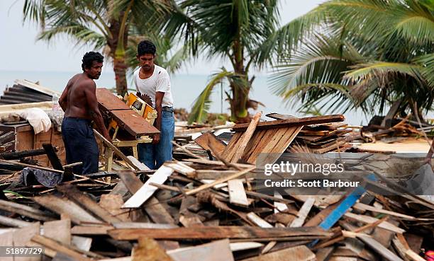 Two men clear debris after the massive tsunami wave swept across coastal Sri Lanka, December 28, 2004 in Colombo, Sri Lanka. Over 55,000 people have...