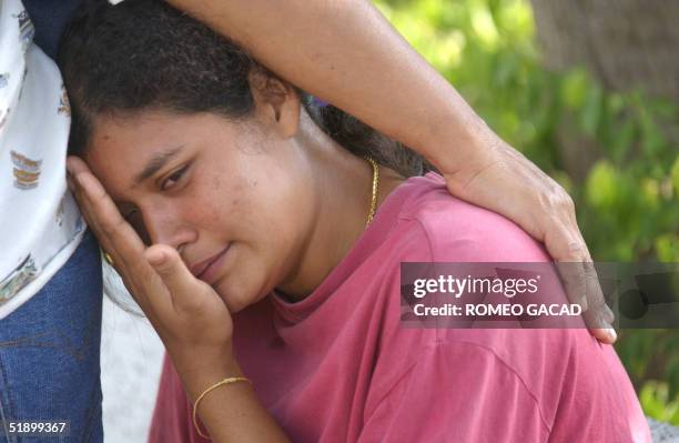 Thai woman looking for her missing relative, grieves outside a makeshift morgue of the government Patong hospital in Phuket, 29 December 2004....