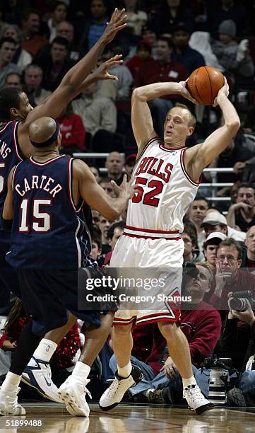 Eric Piatkowski of the Chicago Bulls attempts to shoot over Vince Carter and Jason Collins of the New Jersey Nets at the United Center on December...