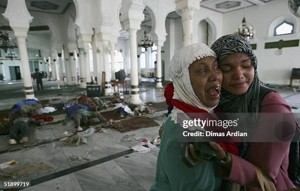 Two Acehnese women mourn for the death of relatives in a mosque in the Indonesian City of Banda Aceh - 150 miles from southern Asia's massive...