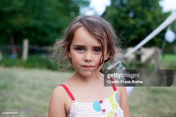 portrait of a young girl looking into a camera - childs pose stockfoto's en -beelden