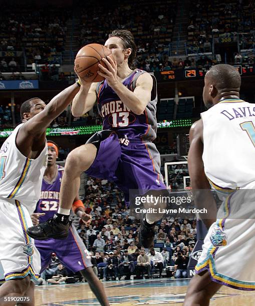 Steve Nash of the Phoenix Suns passes the ball against Corsley Edwards and Baron Davis of the New Orleans Hornets at the New Orleans Arena on...