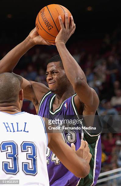 Desmond Mason of the Milwaukee Bucks holds the ball over his head against Grant Hill of the Orlando Magic during a game at TD Waterhouse Centre on...