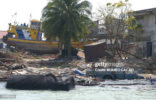 Pick up truck floats amongs debris as a fishing boat rest on land in the devastated fishing village of Nam Kem, in Panga province 30 December 2004...