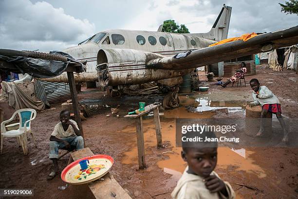 Children tend food stalls around a disposed airplane inside M'poko IDP camp near Bangui Airport on November 6, 2015 in Bangui, Central African...
