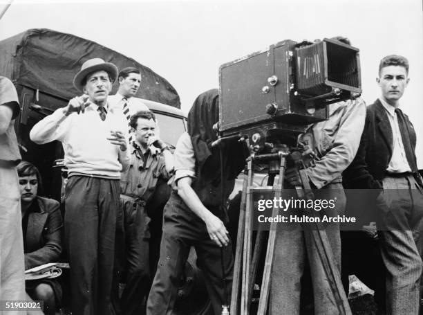 French director Jean Cocteau directs a scene from his film 'La Belle et la Bete' while members of his crew watch, France, 1946.