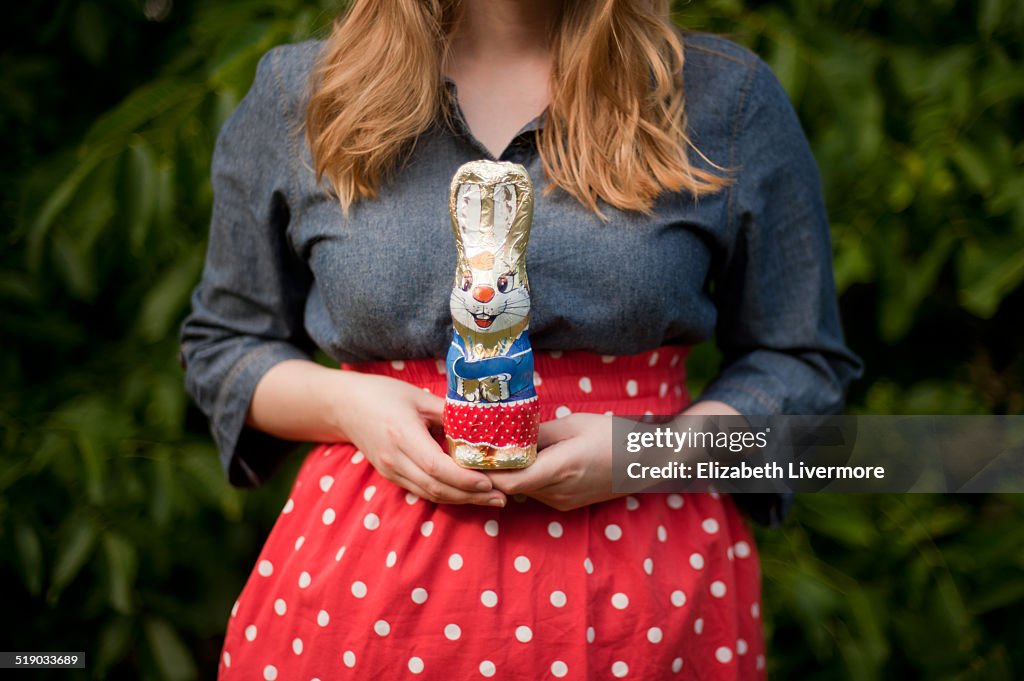 Blonde woman holding rabbit shaped chocolate