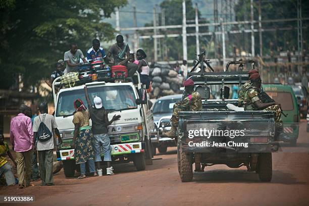 Soldiers, formerly Séléka rebels holding AK-47's, patrol in a pick-up truck on October 28 near the power plant in Bangui as Central Africans ride on...