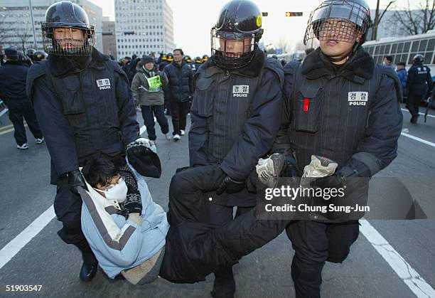 South Korean riot police arrest a protester during a rally demanding the repeal of the National Security Law in front of the National Assembly on...