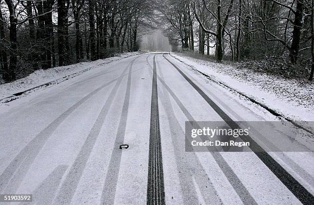 snow falls over the festive season - reifenspur stock-fotos und bilder