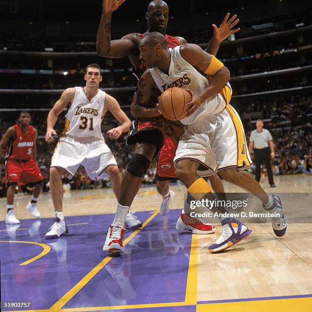 Kobe Bryant of the Los Angeles Lakers drives to the basket against Shaquille O'Neal of the Miami Heat at Staples Center on December 25, 2004 in Los...