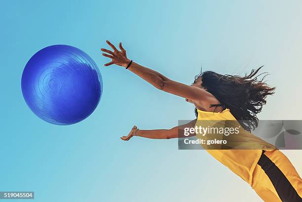 brazilian sportswoman in yellow shirt jumping for blue big ball - brazil and outside and ball stock pictures, royalty-free photos & images