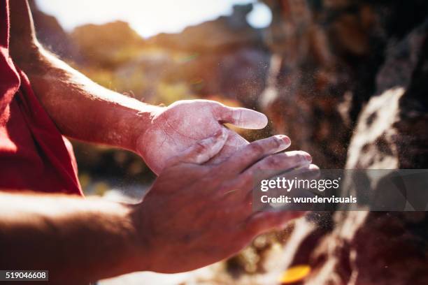 rock climber's hands rubbing chalk in preparation for climbing ascent - caucasian mountain climber man stock pictures, royalty-free photos & images