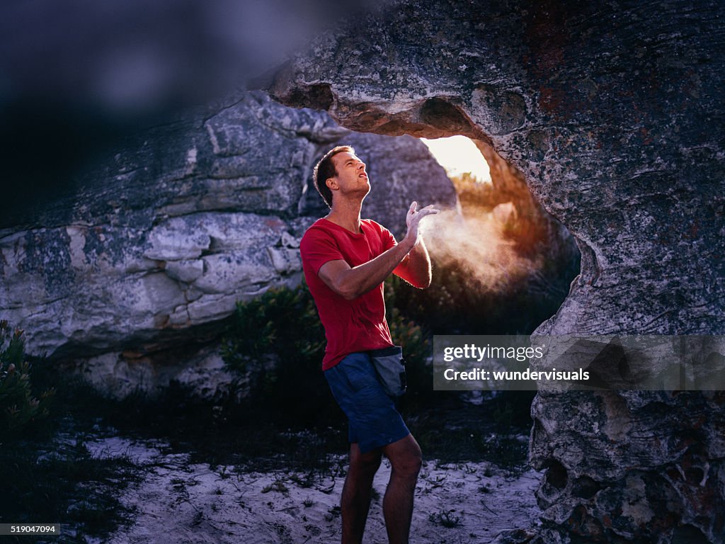 Rock climber applying chalk to hands in preparation for climbing