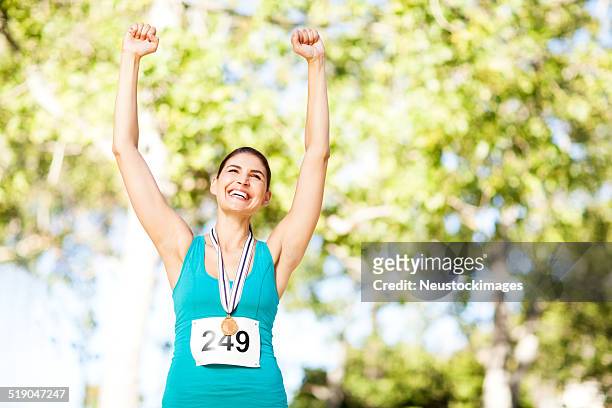 ecstatic marathon gold medalist at park - marathon medal stock pictures, royalty-free photos & images