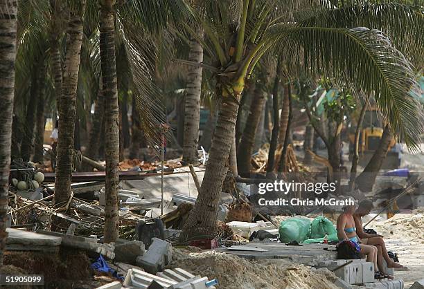 Holiday makers catch some sun amongst the devastation on Patong Beach, December 31, 2004 in Patong, Thailand. Tourists have begun to return to the...