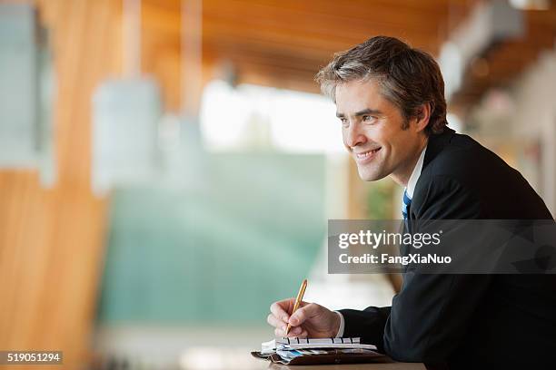 businessman with a planner - meeting candid office suit stockfoto's en -beelden