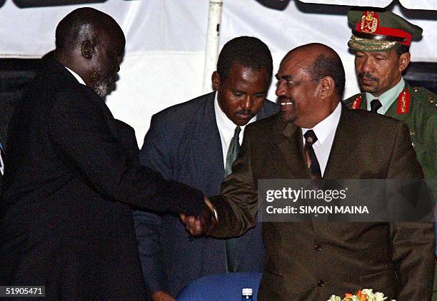 Sudanese President Omar El Bashir shakes hands with the leader of Sudan's People Liberation Movement/Army John Garang after the signing of accords on...