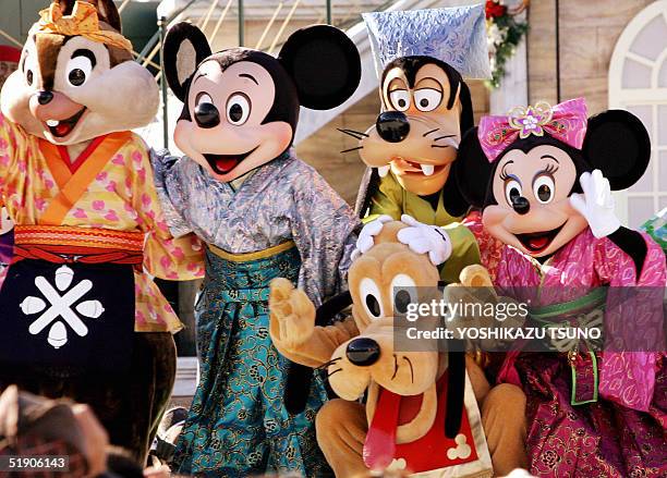 Disney characters Chip, Mickey Mouse, Pluto, Goofy and Minnie Mouse dressed in kimonos wave to greet guests during a New Year's event at the Tokyo...