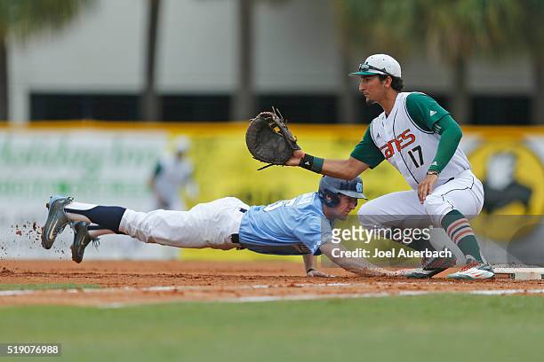 Brian Miller of the North Carolina Tar Heels gets back to first base safe ahead of the ball reaching Christopher Barr of the Miami Hurricanes on...