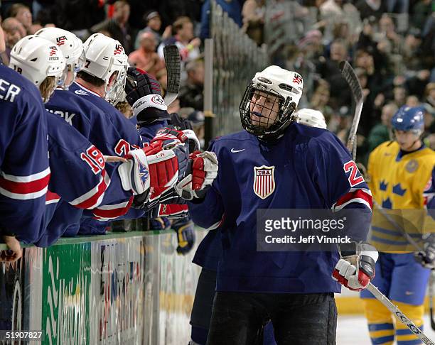 Forward Phil Kessel of Team USA is congratulated by teammates after scoring against Sweden during their quarter-final game at the World Junior Hockey...