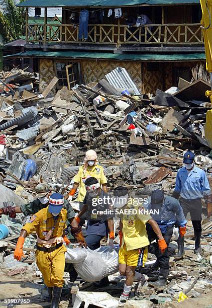 Thai rescuers take away the body of an unidentified western tourist after recovering it from the debris of the washed away bangalow of P.P Valentine...