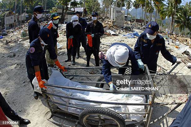 Thai rescuer writes numbers on the dead bodies after recovering from the debris of several washed away bangalows on Phi Phi Island, 02 January 2005....