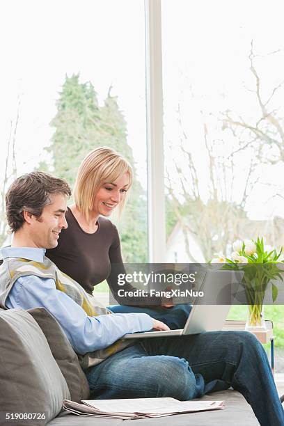 couple sitting together using laptop - newspaper luxury bildbanksfoton och bilder