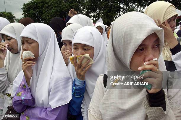 Indonesian Muslim women mourn during mass prayer for Aceh quake and tidal wave victims in Jakarta, 02 January 2005. The multinational operation to...