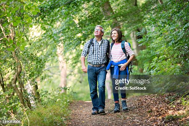 elderly couple out for a walk - bos stockfoto's en -beelden