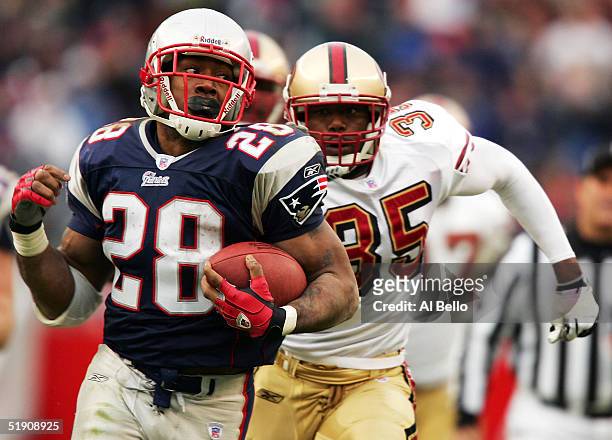 Corey Dillon of the New England Patriots runs past Dwaine Carpenter of the San Francisco 49ers during their game on January 2, 2005 at Gillette...