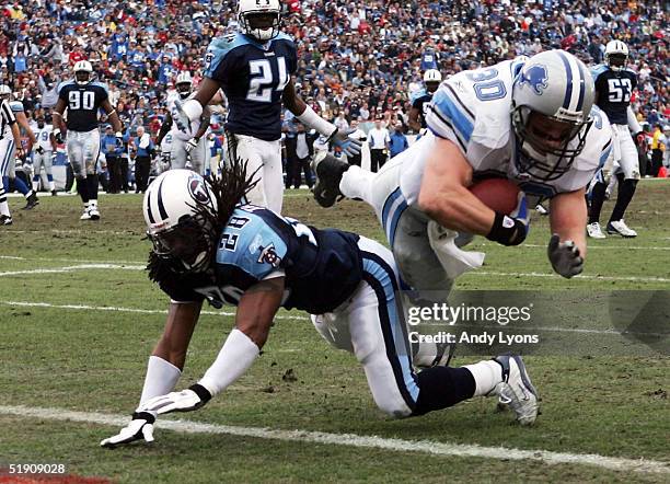 Cory Schlesinger of the Detroit Lions scores a touchdown while tackled by Lamont Thompson of the Tennessee Titans during the NFL game at The Coliseum...