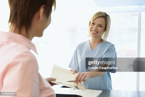 women in a medical office - receptionist stock pictures, royalty-free photos & images