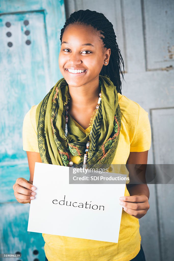Beautiful African teenage girl holding ""education"" sign