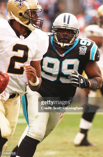 Brentson Buckner of the Carolina Panthers chases Aaron Brooks of the New Orleans Saints at Bank of America Stadium on January 2, 2005 in Charlotte,...