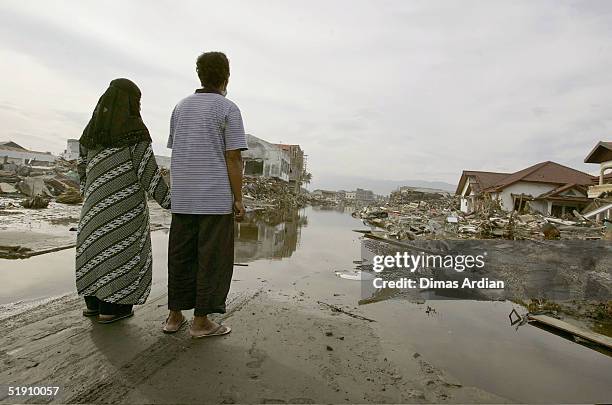 Jasmi and his wife Sunarti are seen holding hands in their former residential area that was leveled by Sunday's tsunami on January 3, 2005 in Banda...