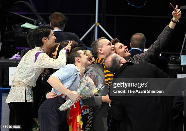 Silver medalist Yuzuru Hanyu and gold medalist Javier Fernandez of Spain pose with their staffs and coaches after the medal ceremony for the Men's...