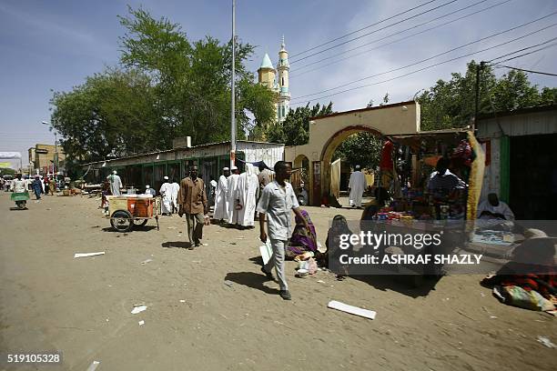 Sudanese men walk at a market in the city of Nyala, in south Darfur, on April 4, 2016. Sudanese President Omar al-Bashir is a tour of Darfur ahead of...