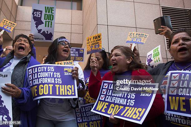 Service Employees International Union members celebrate after California Governor Jerry Brown signed landmark legislation SB 3 into law on April 4,...